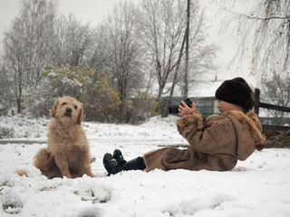 The child takes pictures of the dog. Funny photo shoot of your favorite pet