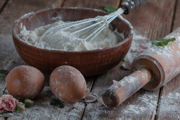 Still life with flour and spoons with a roll, a strainer. supplied on a wooden basis