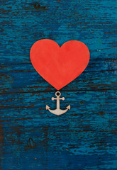 wooden heart and anchor on the rustic painted wooden board
