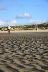 Spaziergänger am Strand bei Ebbe an einem windigen Herbsttag
