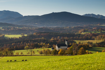 Die Wilpartinger Wallfahrtskirche vor den bayrischen Alpen im Herbst in der Morgensonne, Bayern, Deutschland