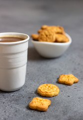 Cup of coffee with sweet mini cookies  on grey concrete background. Free space for text.