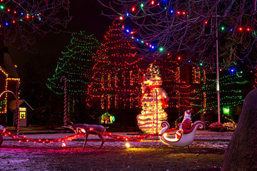 A village Christmas display with a Santa in sleigh, snowman, and nativity scene