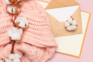 Female pink knitted sweater, cotton, open blank notebook, love letter on pastel pink background top view flat lay. Lady winter Clothes. Cotton flowers. Lifestyle gentle female background