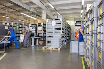 Workers in small warehouse with a variety of boxes