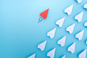 Red paper plane are different from others on blue background. Think different. Business for...