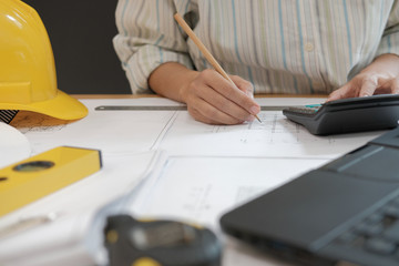 Fototapeta premium architect working on house blueprint of real estate project at workplace. engineer using calculator. building construction concept