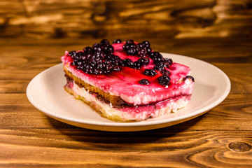 Ceramic plate with cheesecake on wooden table