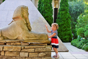 A little funny girl looks at the old Park imitation of Egyptian attractions.