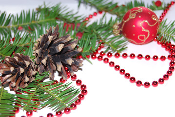 Christmas and New Year holidays. On a white background sprigs of coniferous tree with red berries. Red christmas balls, red balls and red beads.