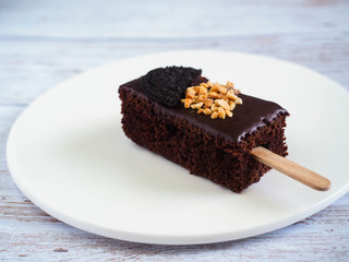 Close up Chocolate Brownies with Nuts and cookie on top in white plate.