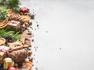 Bright Christmas or New Year background with thuja branches, Christmas decorations, spices, nuts, dried orange slices, pine cones. Copy space.