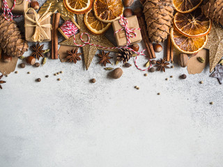 Brown, gold and orange Christmas or New Year background with Christmas decorations, spices, nuts, dried orange slices, pine cones. Copy space. Top view