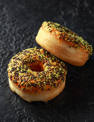 Orange Donut with sprinkles on rustic dark background
