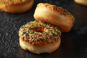 Orange Donut with sprinkles on rustic dark background