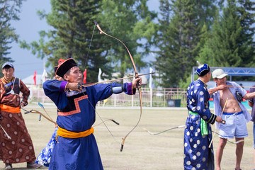 Young man shoots from a sports bow