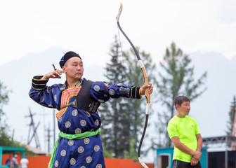 Young man shoots from a sports bow