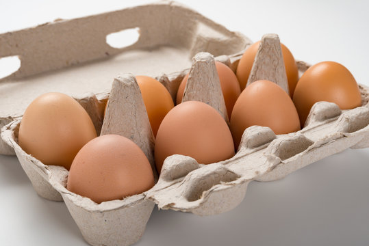fresh eggs in a paper package close up on white