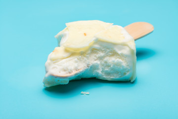white popsicle with lots of bites on blue background
