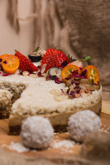 Cake with berries and fruit close-up. White cake on a wooden table.