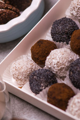 Candy in a white box close-up. Brown round candies, nuts, cinnamon