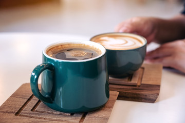 Close up image of a hand holding a green coffee mugs in cafe
