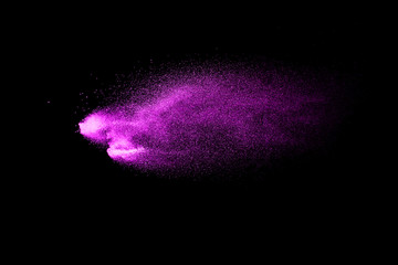 Pink dust particles splash on black background.