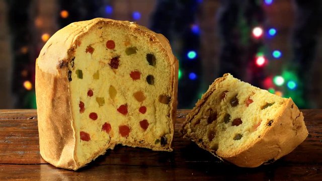panettone, decorative christmas food, on wooden table with lights flashing in the background