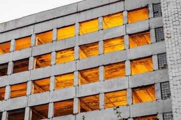 Old concrete building unfinished abandoned, rays of light through the windows