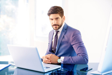 Young business person sitting behind notebook in the office