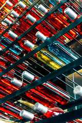 Rows of colourful wine bottles, Detail image of Metal rack with plenty of wine bottles composed in rows for decor.