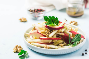 Apple, celery root walnut salad with olive oil, mustard, honey dressing. Selective focus, space for text.