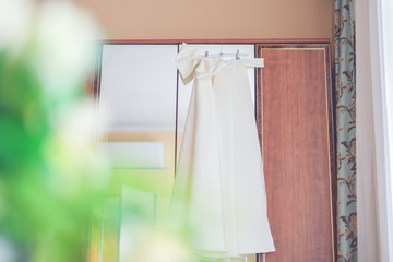 Wedding dress (skirt) hanging on the hanger on the closet.