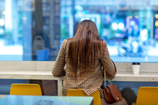 Young Woman Sitting Alone In A Coffee Shop