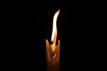 Burning candle on a black background