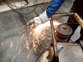 Worker in factory, Welding and Grinding Steel wire, Flash of fire from grinding stone, Metal industry, Operator working in the site, Workplace,  steel structures manufacture workshop