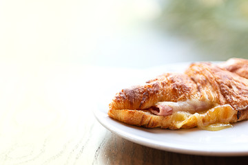 Croissant ham cheese, France food in plate on table.