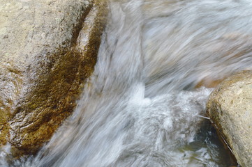 water flowing on the rock and wave splashing in river