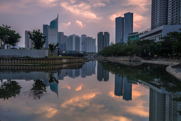 Magnificent of Jakarta cityscape. Office buildings reflected on the water with cloudy sky in the...