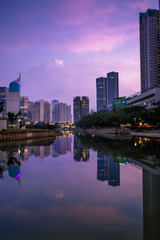 Naklejka premium Beautiful scenes of reflected office buildings on the water with cloudy sky in the dusk, Jakarta, Indonesia
