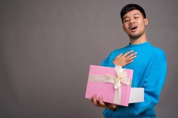 Portrait of young Asian man holding gift box