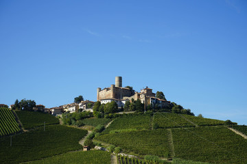 Fototapeta na wymiar View of the Langhe hills with the village of Castiglion Falletto and his castle, Piedmont - Italy