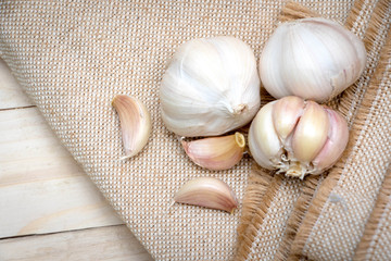 Organic garlic bulbs on burlap background.