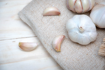 Organic garlic bulbs on burlap background.