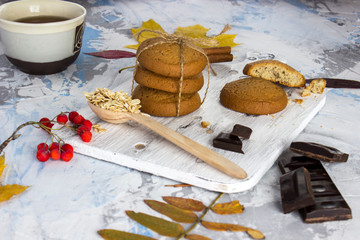 oatmeal cookies with chocolate and tea on the background of a granite table and a white wall