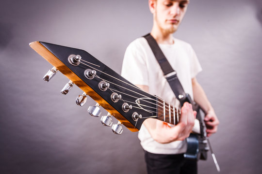 Young man is playing electric guitar
