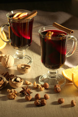 Two cups with ready mulled wine with anise, cinnamon and nuts around