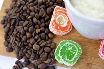 coffee beans and sweets on a white saucer