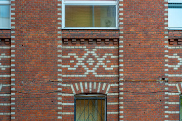 Fototapeta na wymiar The facade of a brick building with a white patterned bricks