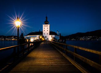 illuminated boardwalk to the Schloss Ort in Gmunden on the Traunsee at twilight hour